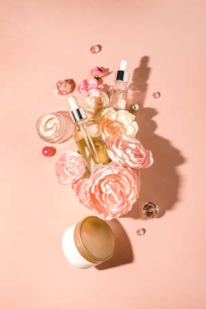 Natural cosmetics, bio serum and herbal oils and cream for spa and skin care in a composition with flowers. Trendy monochrome pastel background, flat lay. Natural skin care conceptの写真素材