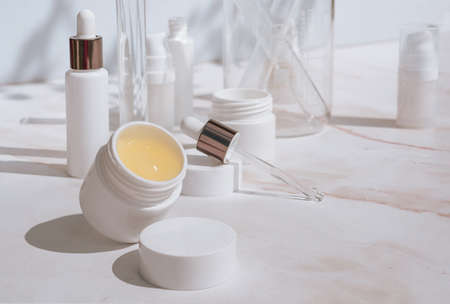 Natural cosmetic products in white packaging with laboratory glassware. Science and skincare conceptの写真素材