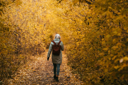 A young girl, a teenager, walks alone in an autumn park.