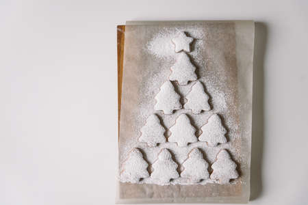 Gingerbread Christmas tree sprinkled with powdered sugar on parchment