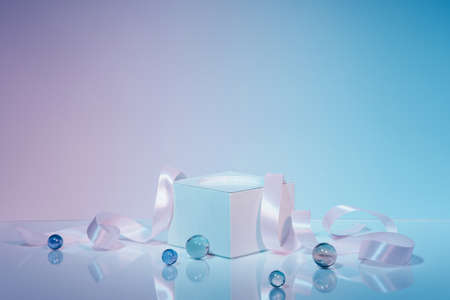 White rectangular podium with satin ribbon on two-tone background with transparent balls