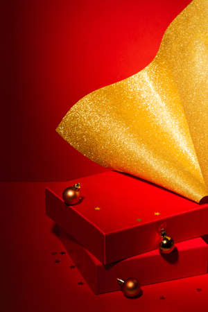 Empty Red podium with gift boxes, gold Christmas decor Red background.の写真素材