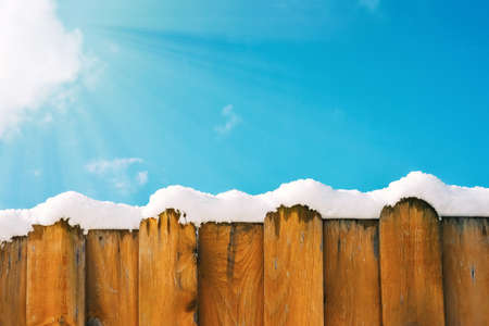Fence in snow against the sky, winter background, copy spaceの写真素材