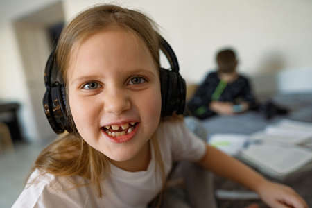 Ggirl in big headphones, smile, growing teeth are visible, funの写真素材