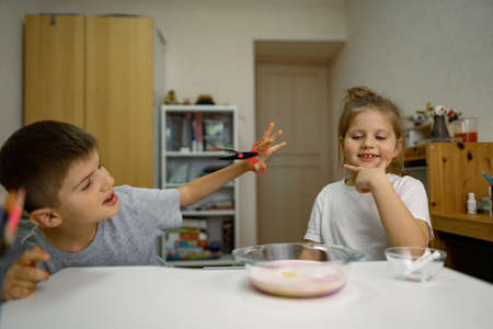 Children, girl, boy are having fun at home, experimenting with milk and paintsの写真素材