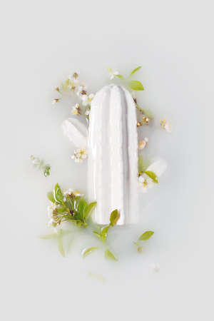 White figurine of cactus with flowers, leaves on milky background.