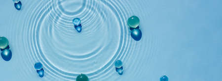 Abstract water, cosmetic background with waves and ripples and glass granulesの写真素材