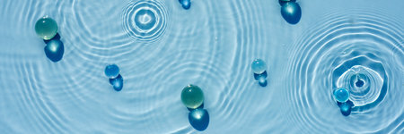 Abstract background, texture of blue water with round ripples with transparent balls, capsulesの写真素材