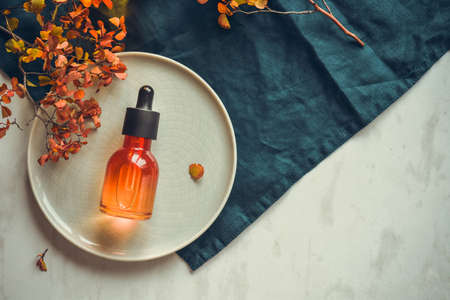 Serum with hyaluronic acid in a bottle with a pipette on a round dish. The concept of luxury anti-aging skin care.の写真素材