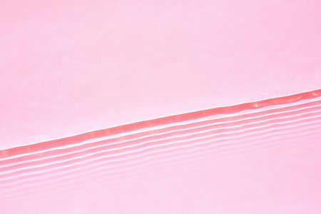 Transparent pink water surface texture with horizontal waves and ripplesの写真素材