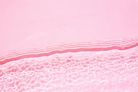 Background, texture of transparent pink water with seething ripples , wavesの写真素材