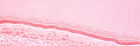 Background, texture of transparent pink water with seething ripples , wavesの写真素材