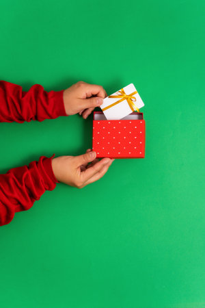 Female hands take out a bonus or gift bank card template from gift boxの写真素材