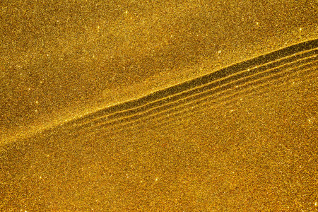 Abstract golden glitter texture with waves and ripples, sparkling backgroundの写真素材