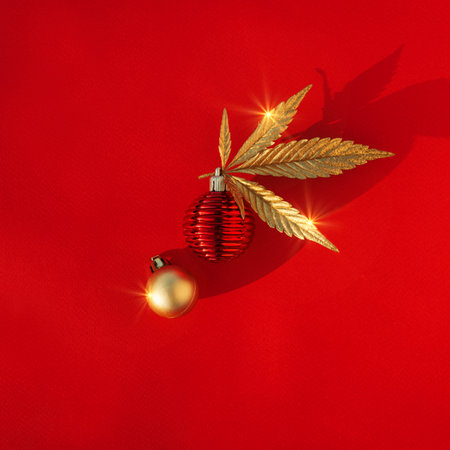 Abstract red christmas background with golden cannabis, marijuana leaf and festive decor.の写真素材