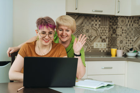 Adult mother and daughter communicate, greet relatives via video conversationsの写真素材