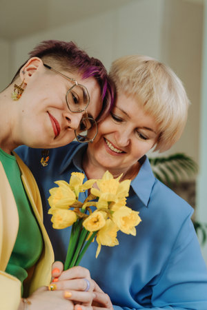 Moments of Love: Daughter Presents Beautiful Flowers to 55-Year-Old Mom at Homeの写真素材