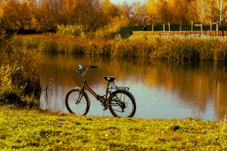 Autumn landscape of the park with a bike on lakeの写真素材