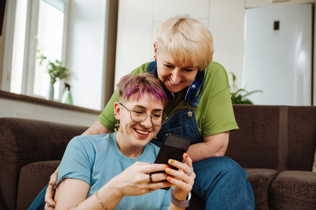 Elderly mom with her daughter use smartphone to learn online skills in room