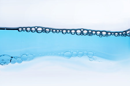 Wave of transparent liquid with bubbles, cosmetic essence close-up. Hydration skin care concept with...