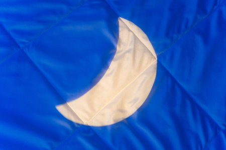 Crescent moonlight on blanket at night in bedroom, background. Conceptual background for products with melatonin, cannabis oil to relax and improve the quality of sleep at night while you sleepの写真素材