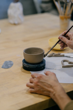 Close-up of a ceramic cup in progress, showing precise craftsmanship. Pottery student learns...