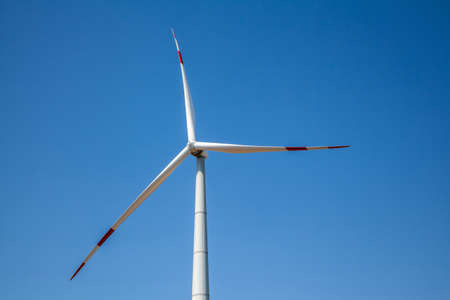 Wind turbine for electricity generation, renewable energy on a blue sky background