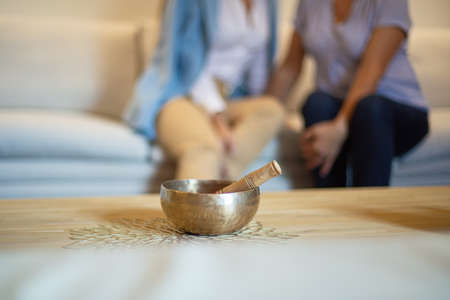 Singing Bowls on the table with people on backgroundの写真素材