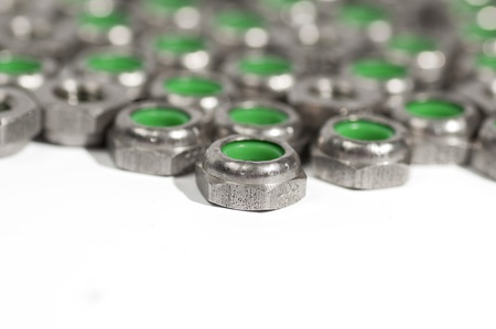 heap of metal nuts with green interior, stacked, isolated on whiteの写真素材