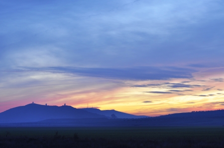 Mountain range silhouette at sunset with colorful skyの写真素材