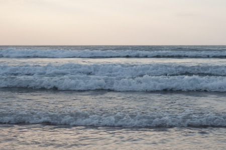 Little waves in the beach at sunset