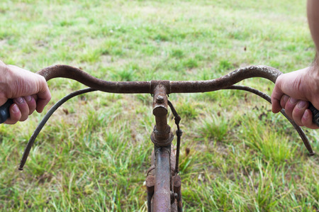 Hands hold an Antique or retro bicycle handlebar outsideの写真素材