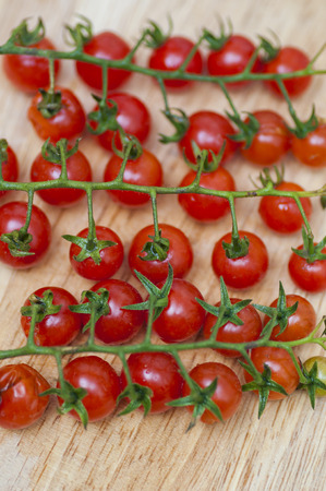 Some red cherry tomatoes in wooden backgroundの写真素材