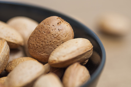 Almonds on a black bowl on wooden の写真素材