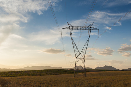 High voltage tower in the fields at sunset