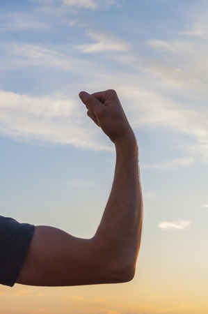 Man posing at sunset, sowing biceps. の写真素材