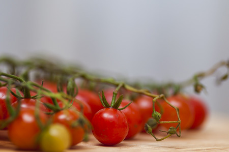 Some red cherry tomatoes in wooden backgroundの写真素材