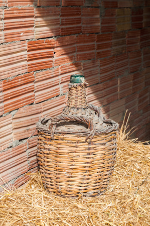 Old glass bottle lined with wood. Used to store wineの写真素材