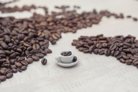 Coffee beans and toy cup with coffee, conceptの写真素材