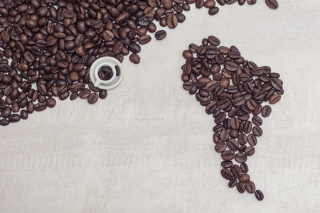 Coffee beans shaped America and toy cup with coffee, conceptの写真素材