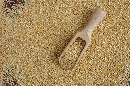 Kinoa seeds in wooden spoons on wooden table, top view, organic foodの写真素材
