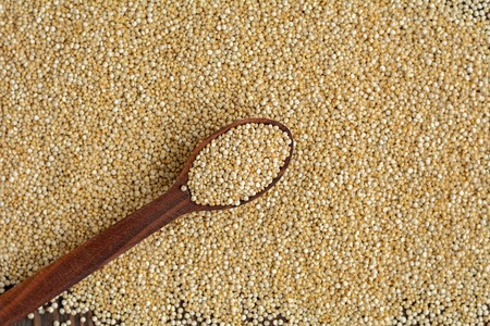 Kinoa seeds in wooden spoons on wooden table, organic foodの写真素材