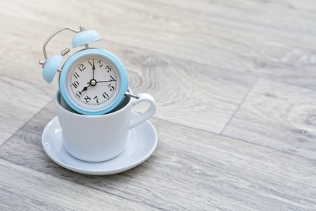 vintage alarm clock on solid light grey color backgroundの写真素材