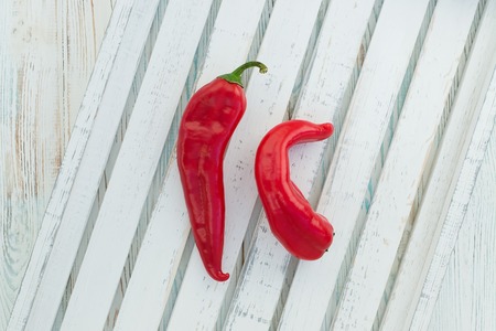 Red hot chili papper on white wooden background, top view
