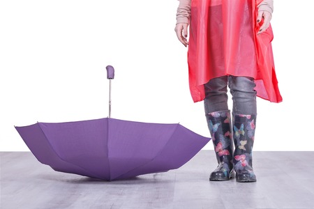 Woman in rubber boots and umbrella on the floorの写真素材