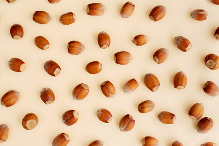 Hazelnuts on yellow background, flatlay