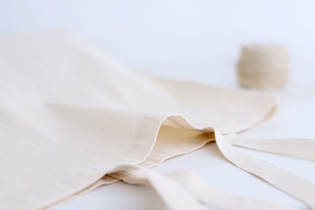 Cotton bag and coil of rope isolated on whiteの写真素材