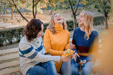 Cheerful attractive three young women best friends having fun together outside.の写真素材