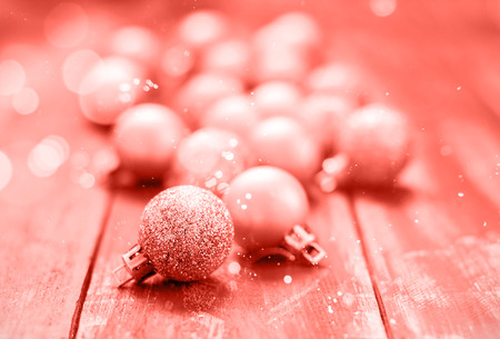 Christmas golden glittered balls on brown wooden background. Copy space. Living Coral creative and moody color of the picture. Color of the 2019 year.の写真素材