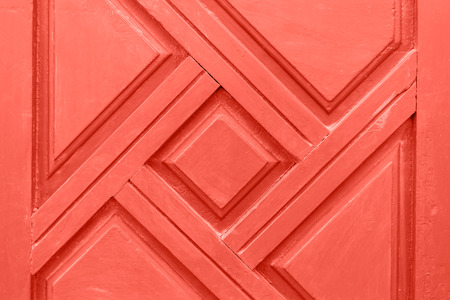 Wooden background with carved ornament. Living Coral color of the 2019 year. Creative and moody color of the picture.の写真素材